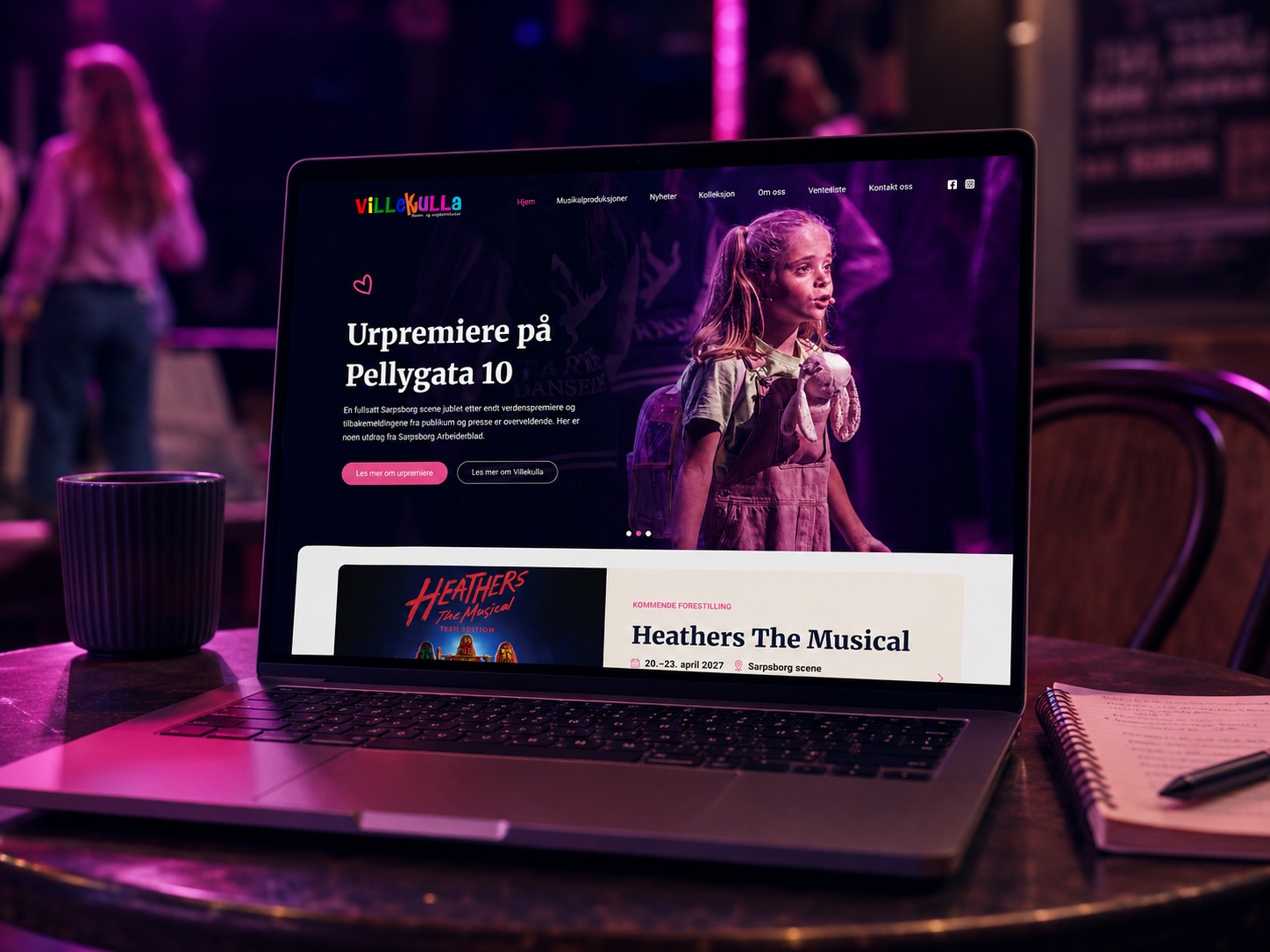 Villekullas nettside vist på en laptop i et teatermiljø
